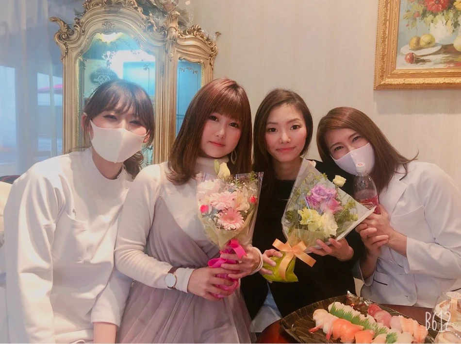 花束を手にした方々と白衣姿の方々が並ぶ記念写真